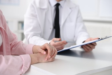 Photo of Woman having appointment with doctor in hospital, closeup