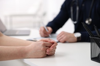 Photo of Woman having appointment with doctor in hospital, closeup