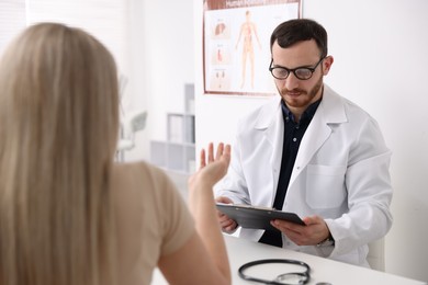 Photo of Doctor and his patient at desk in hospital