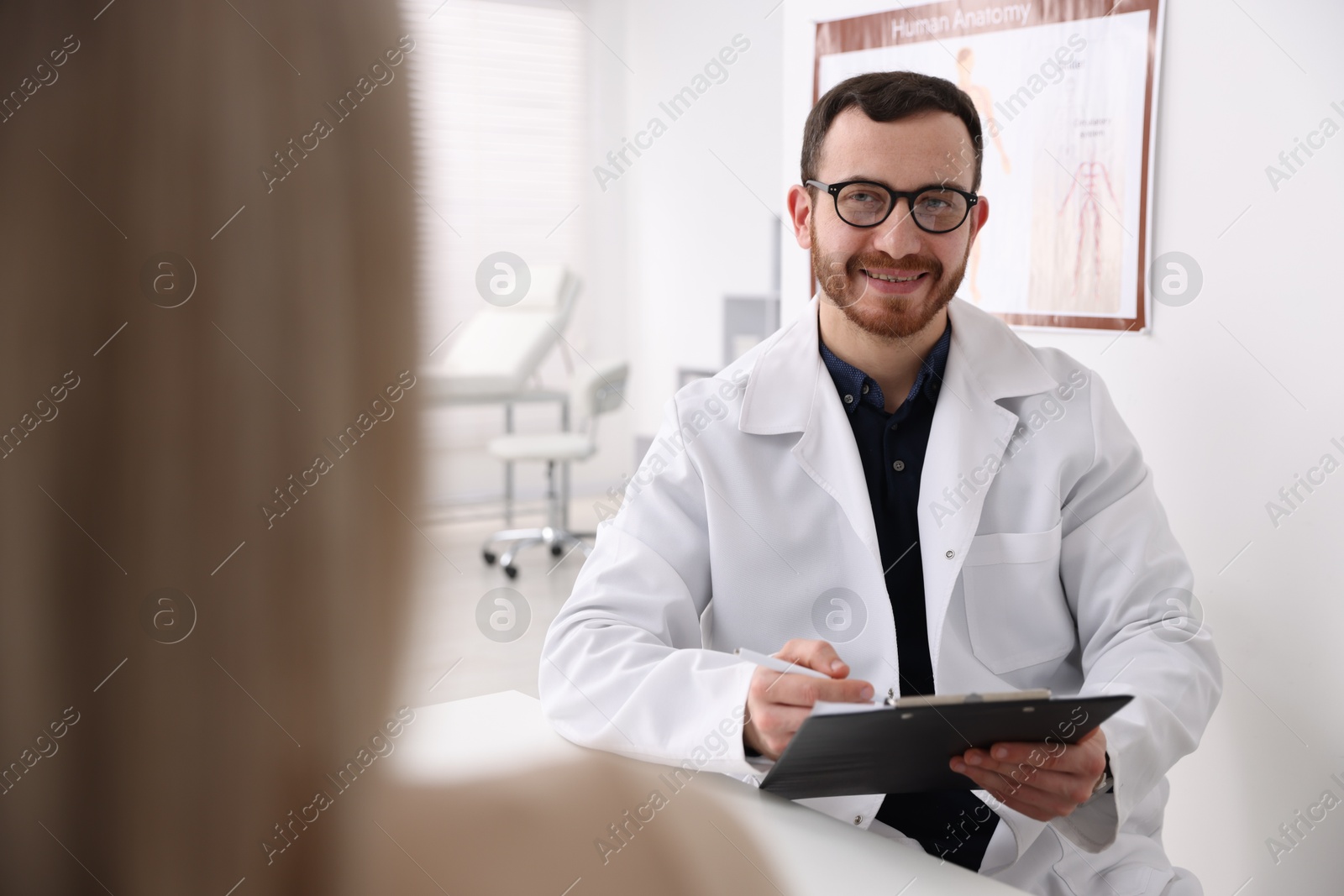 Photo of Doctor and his patient at desk in hospital