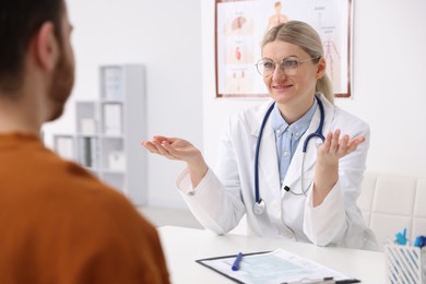 Photo of Doctor and her patient at desk in hospital