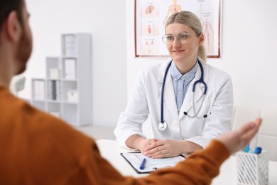 Photo of Doctor and her patient at desk in hospital