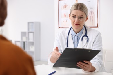 Photo of Doctor and her patient at desk in hospital