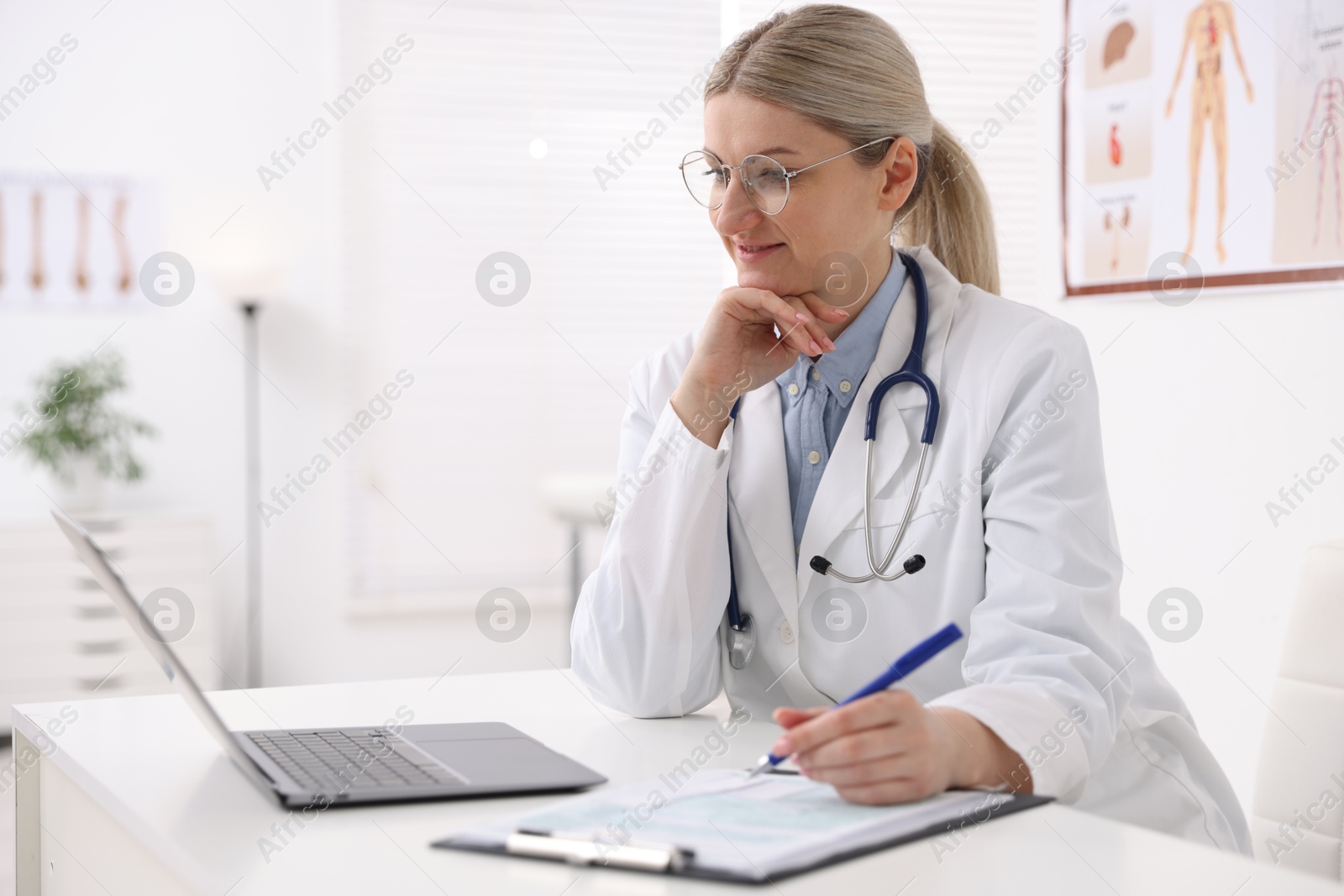 Photo of Professional doctor working at desk in hospital. Space for text