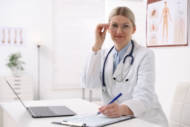 Photo of Professional doctor working at desk in hospital. Space for text