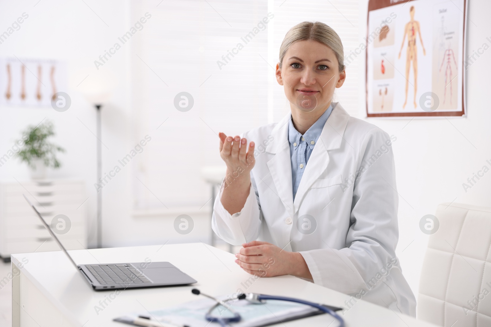 Photo of Professional doctor working at desk in hospital. Space for text