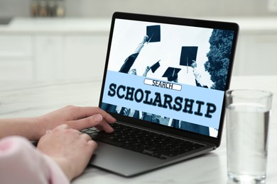 Image of Student searching for scholarships using laptop at home, closeup. Open website on device screen