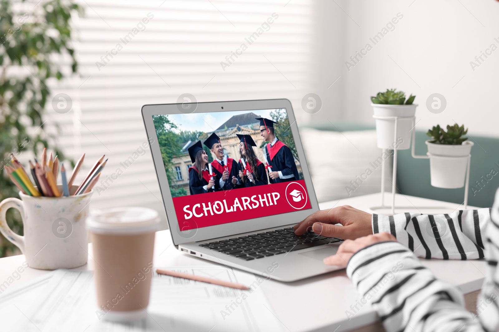 Image of Student searching for scholarships using laptop at home, closeup. Open website on device screen