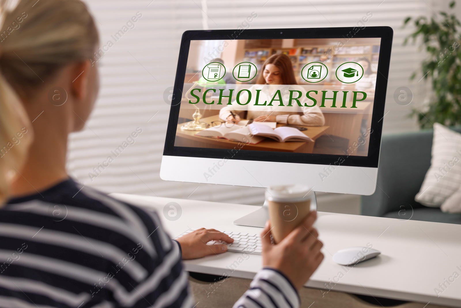 Image of Student searching for scholarships using computer at home. Open website on display