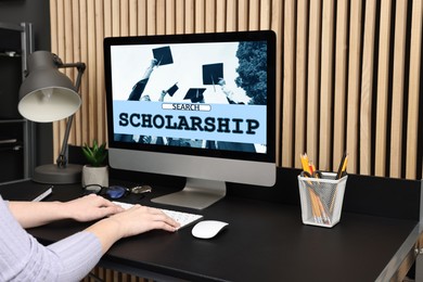 Image of Student searching for scholarships using computer at home, closeup. Open website on display