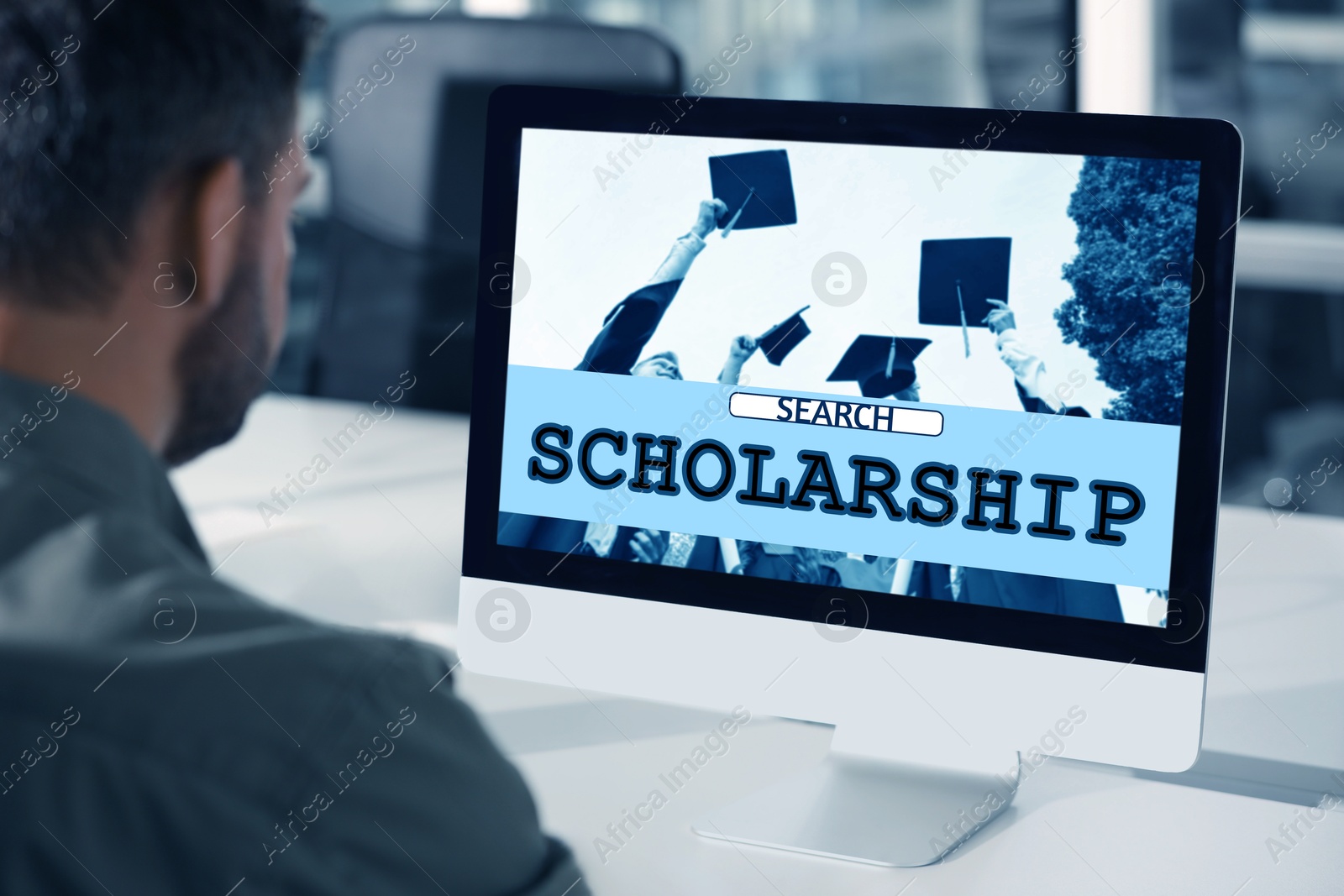 Image of Student searching for scholarships using computer at home. Open website on display