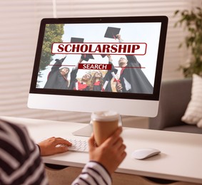 Image of Student searching for scholarships using computer at home, closeup. Open website on display