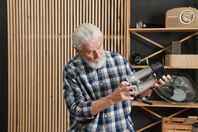 Photo of Relaxing hobby. Senior man repairing blender in workshop