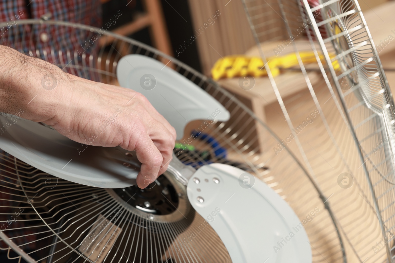 Photo of Relaxing hobby. Senior man repairing fan in workshop, closeup