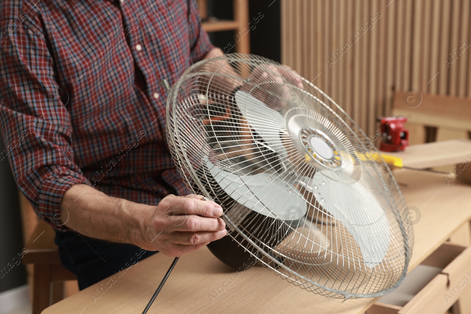 Photo of Relaxing hobby. Senior man repairing fan in workshop, closeup