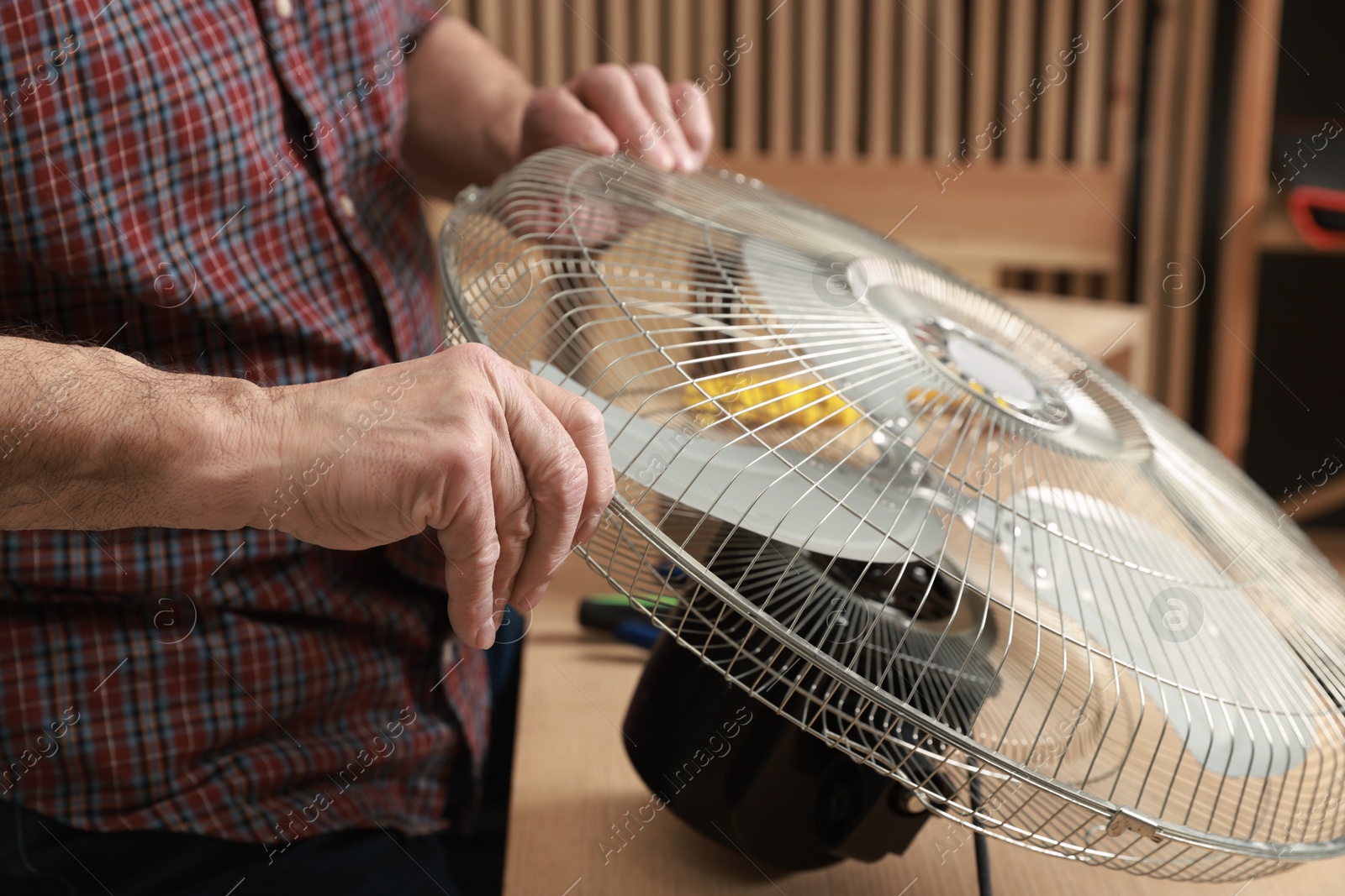 Photo of Relaxing hobby. Senior man repairing fan in workshop, closeup