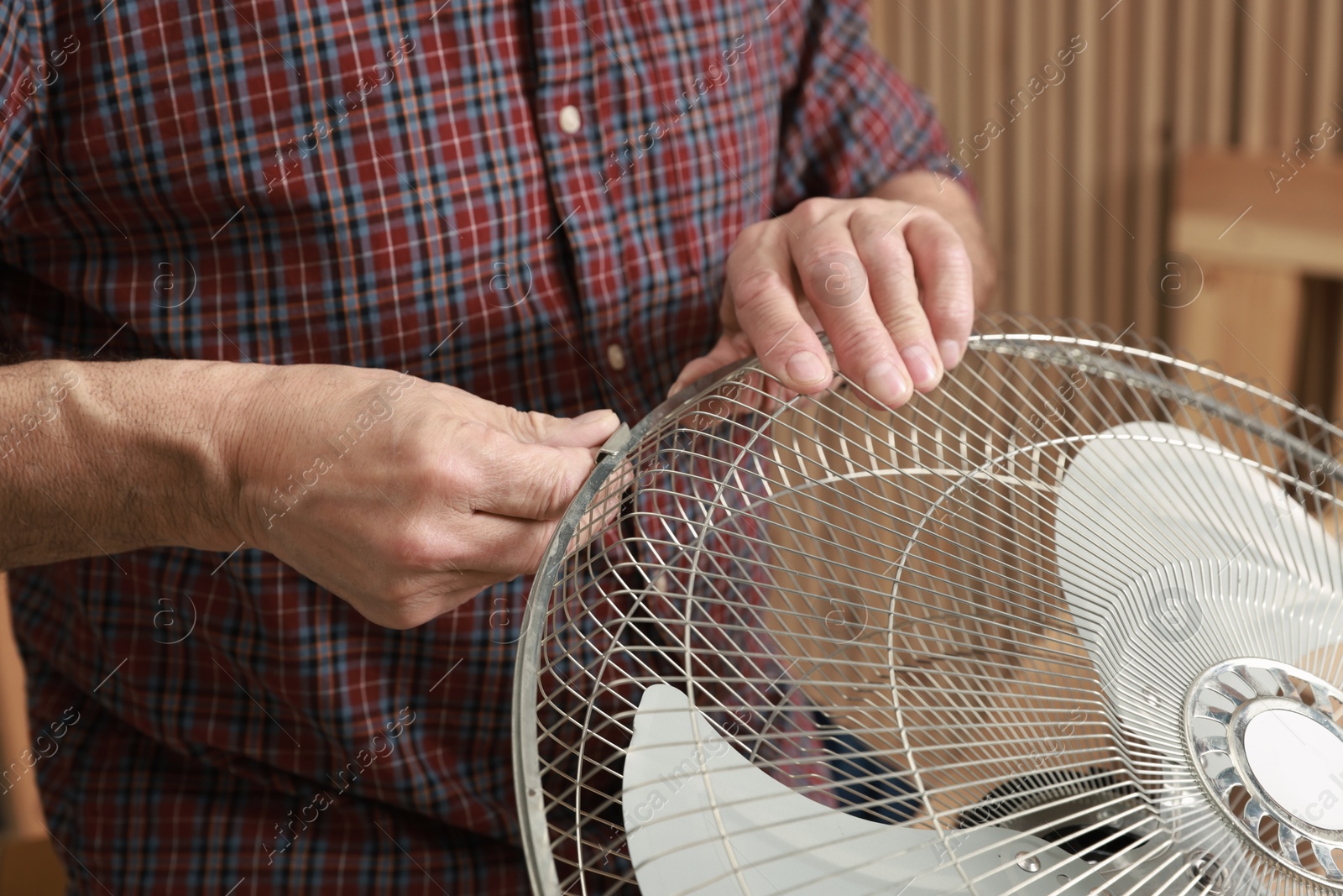 Photo of Relaxing hobby. Senior man repairing fan in workshop, closeup