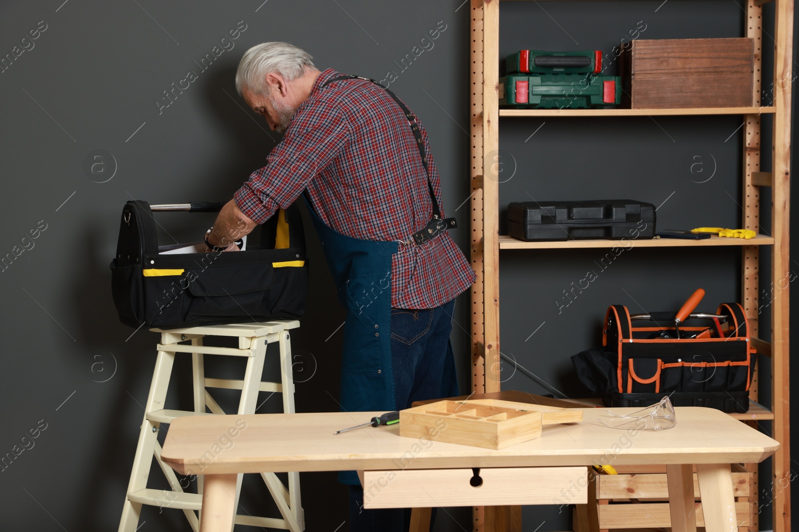 Photo of Relaxing hobby. Senior man with tool bag in workshop