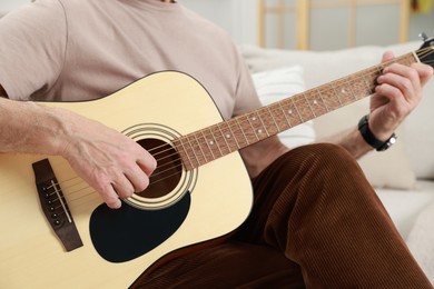 Photo of Relaxing hobby. Senior man playing guitar at home, closeup