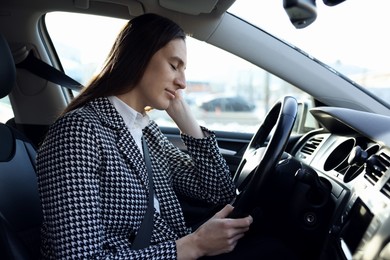 Photo of Tired driver sleeping in her modern car