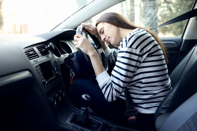 Photo of Tired driver sleeping on steering wheel in car