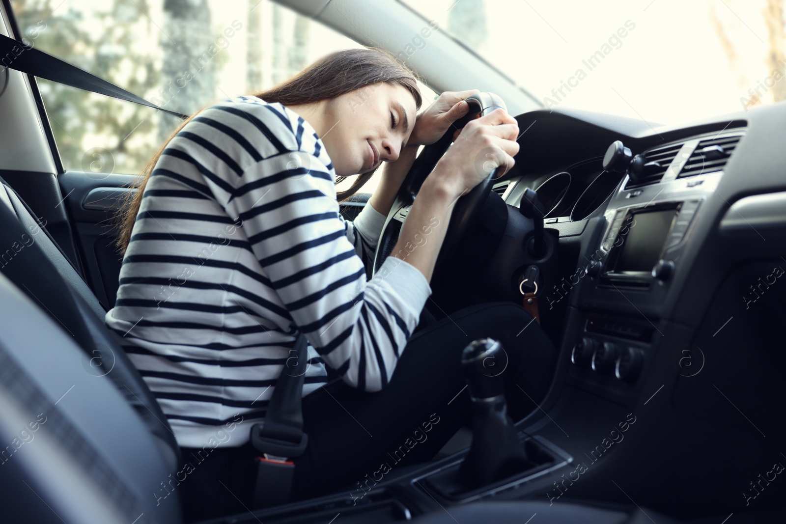 Photo of Tired driver sleeping on steering wheel in car