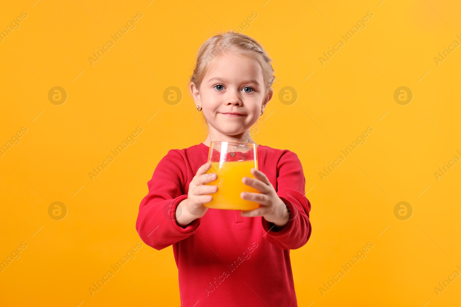 Photo of Girl with glass of juice on orange background. Refreshing drink