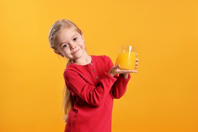 Photo of Girl with glass of juice on orange background. Refreshing drink