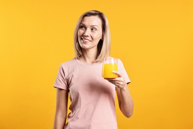 Photo of Woman with glass of juice on orange background. Refreshing drink