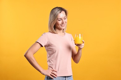 Photo of Woman with glass of juice on orange background. Refreshing drink