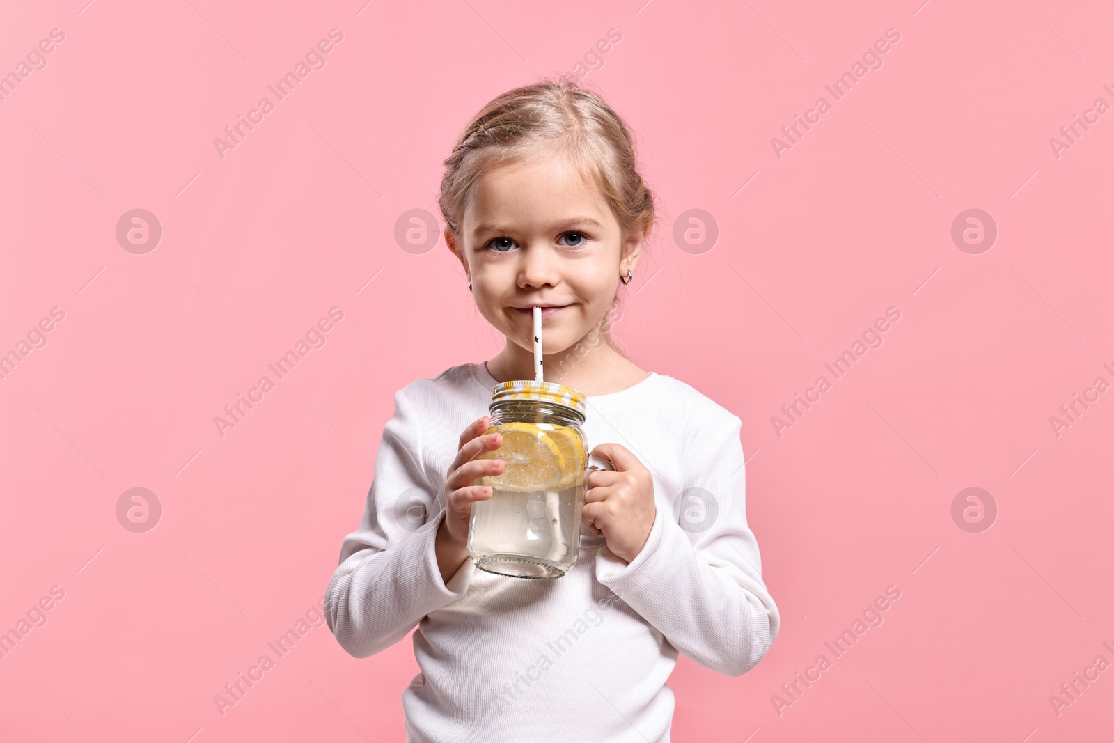 Photo of Girl drinking tasty lemonade on pink background. Refreshing drink