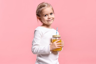 Photo of Girl with mason jar of orange juice on pink background. Refreshing drink