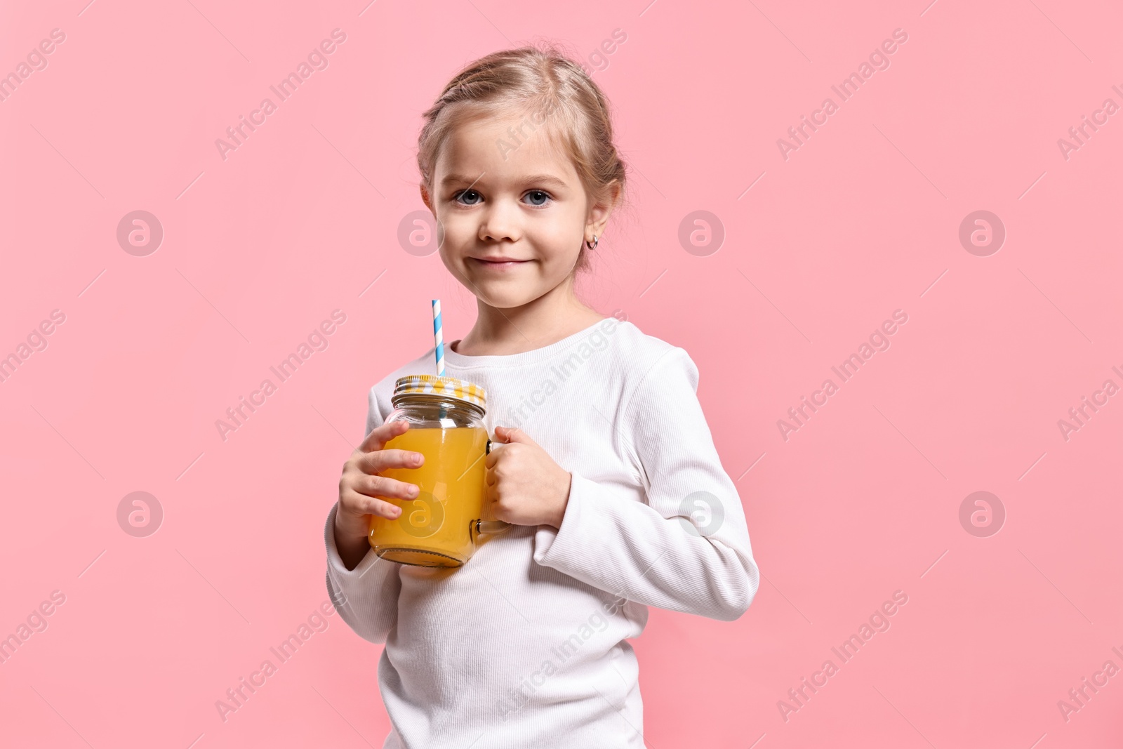 Photo of Girl with mason jar of orange juice on pink background. Refreshing drink