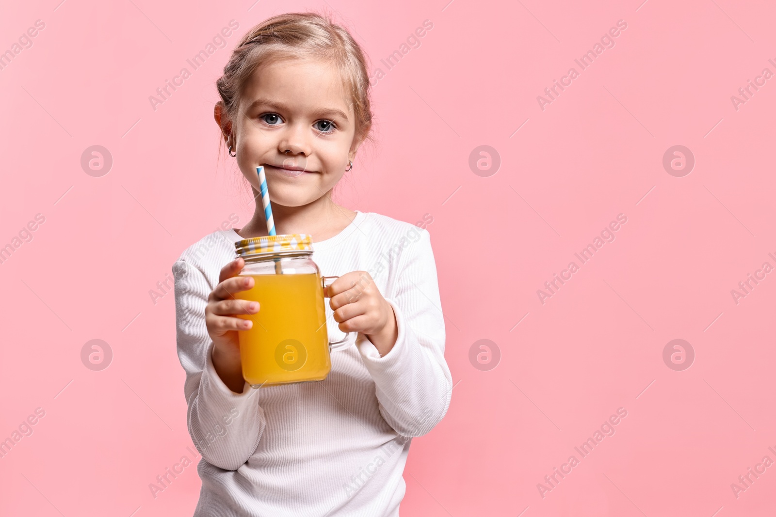 Photo of Girl with mason jar of orange juice on pink background, space for text. Refreshing drink