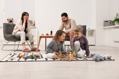 Photo of Hyperactive children playing and their overwhelmed parents at home