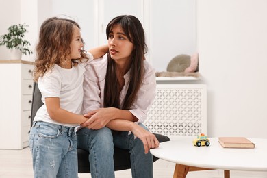 Photo of Overwhelmed mother and her happy daughter at home