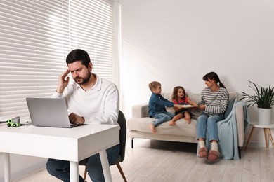 Photo of Noisy children with mother bothering their overwhelmed father at home