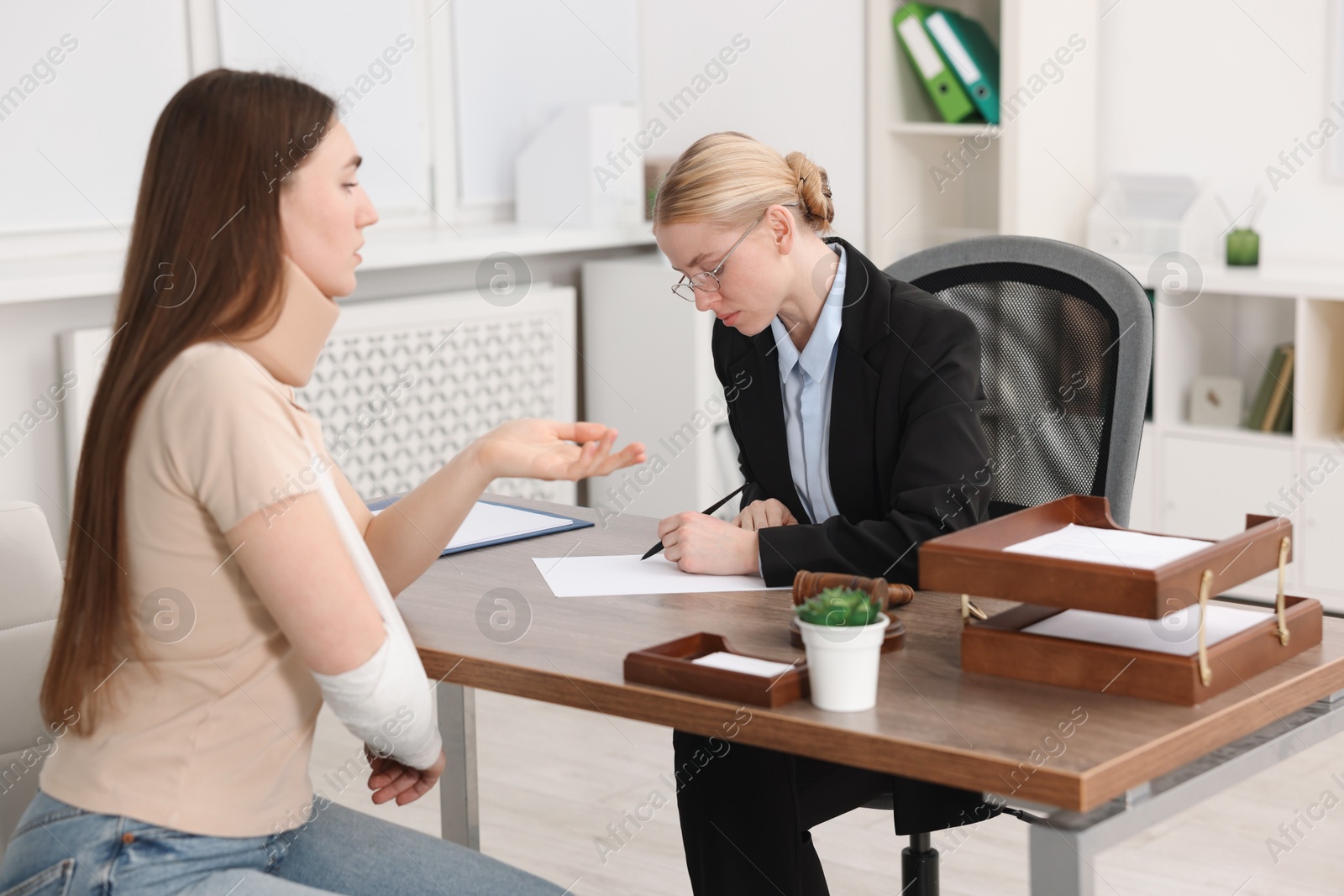 Photo of Injured woman having meeting with lawyer in office