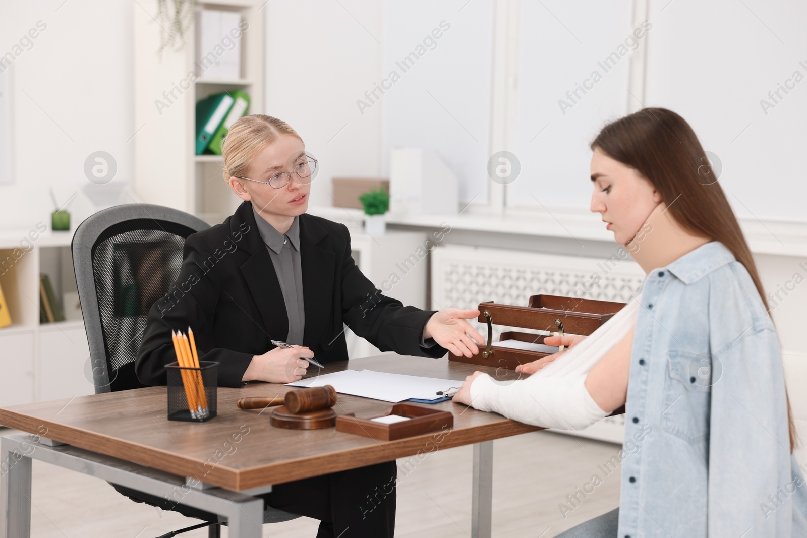 Photo of Injured woman having meeting with lawyer in office