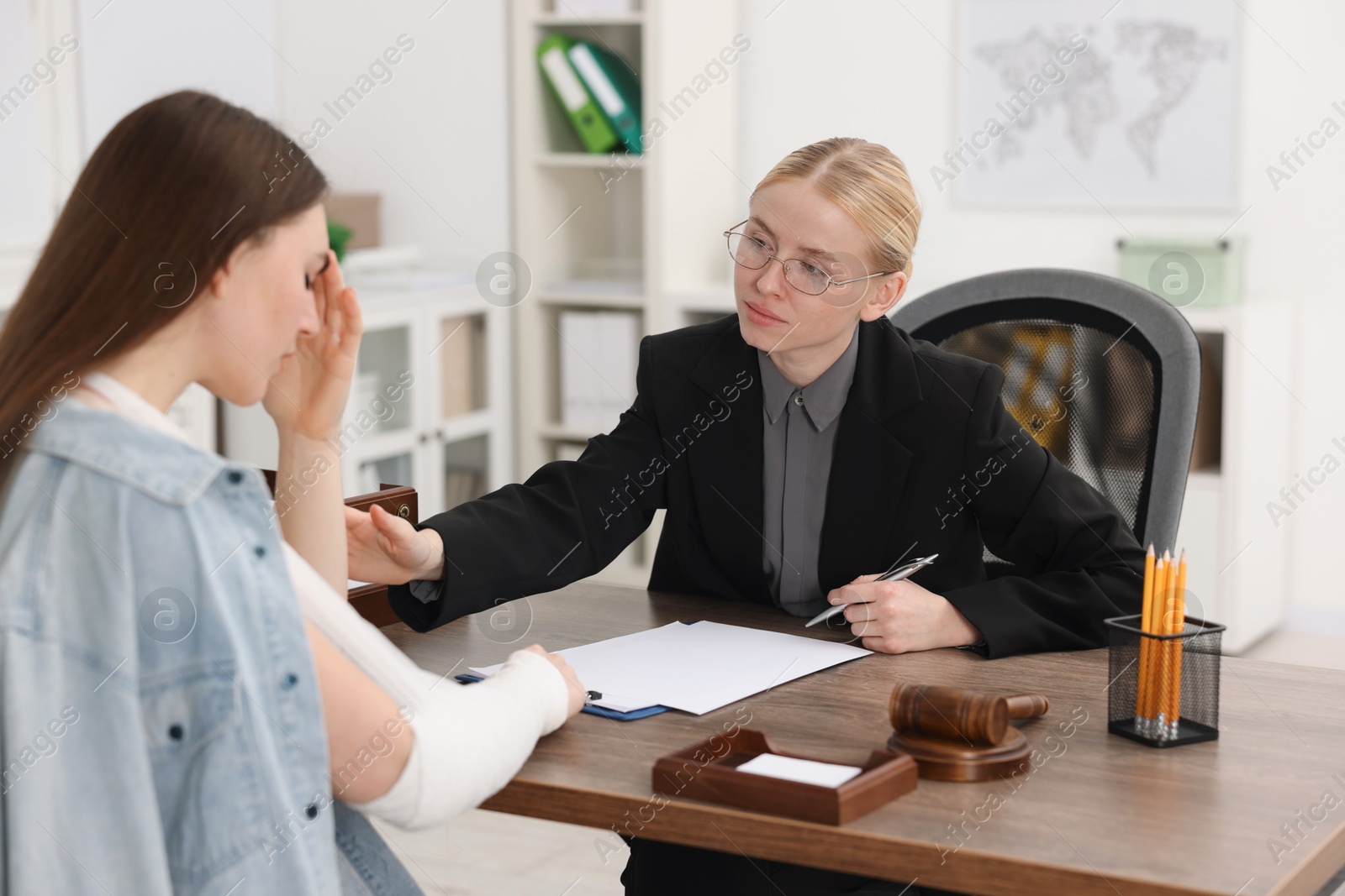 Photo of Injured woman having meeting with lawyer in office, selective focus