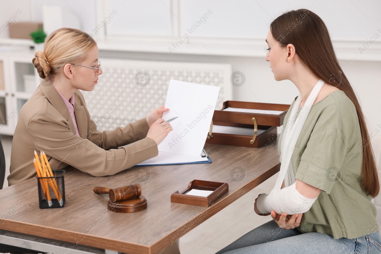 Photo of Injured woman having meeting with lawyer in office