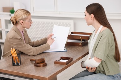 Photo of Injured woman having meeting with lawyer in office