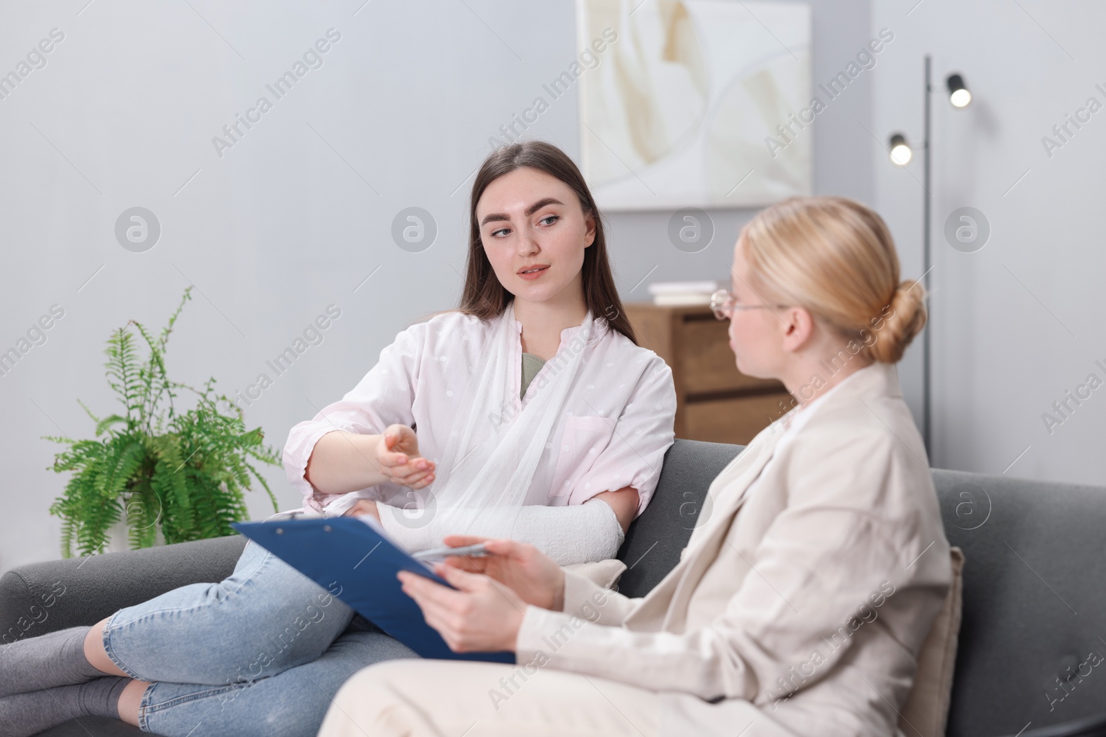 Photo of Injured woman having meeting with lawyer in office, selective focus