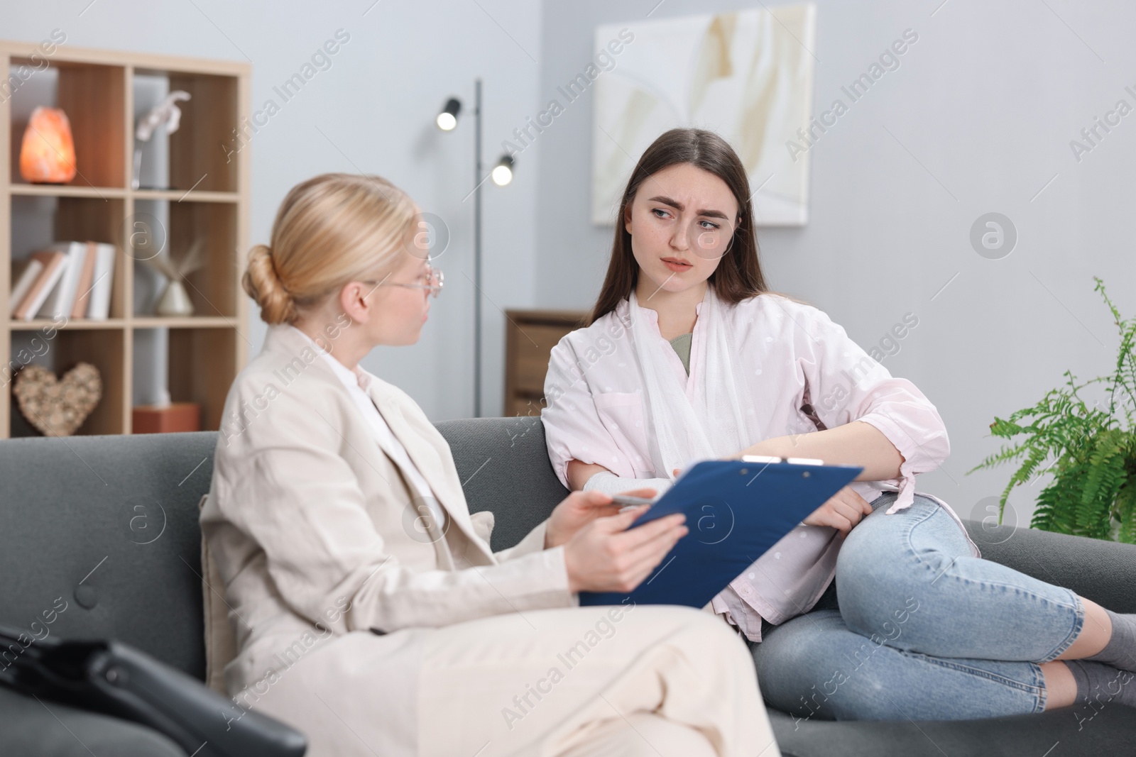 Photo of Injured woman having meeting with lawyer in office, selective focus