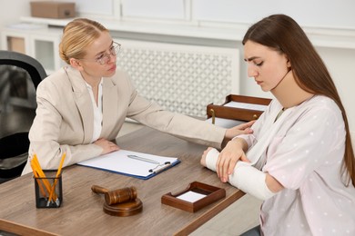 Photo of Injured woman having meeting with lawyer in office