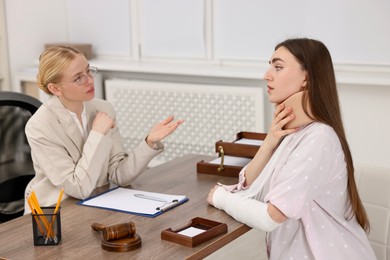 Photo of Injured woman having meeting with lawyer in office