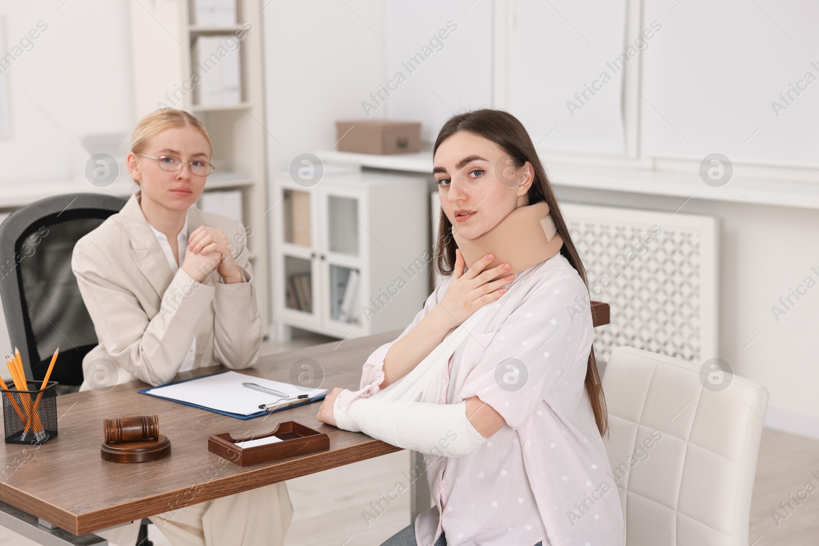 Photo of Injured woman and lawyer in office, selective focus