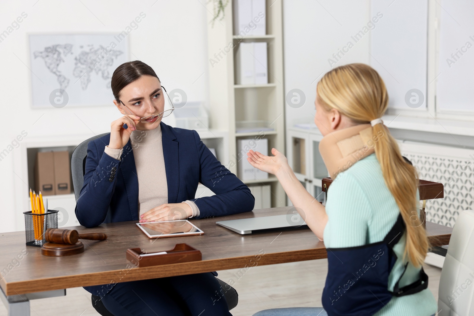 Photo of Injured woman having meeting with lawyer in office, selective focus