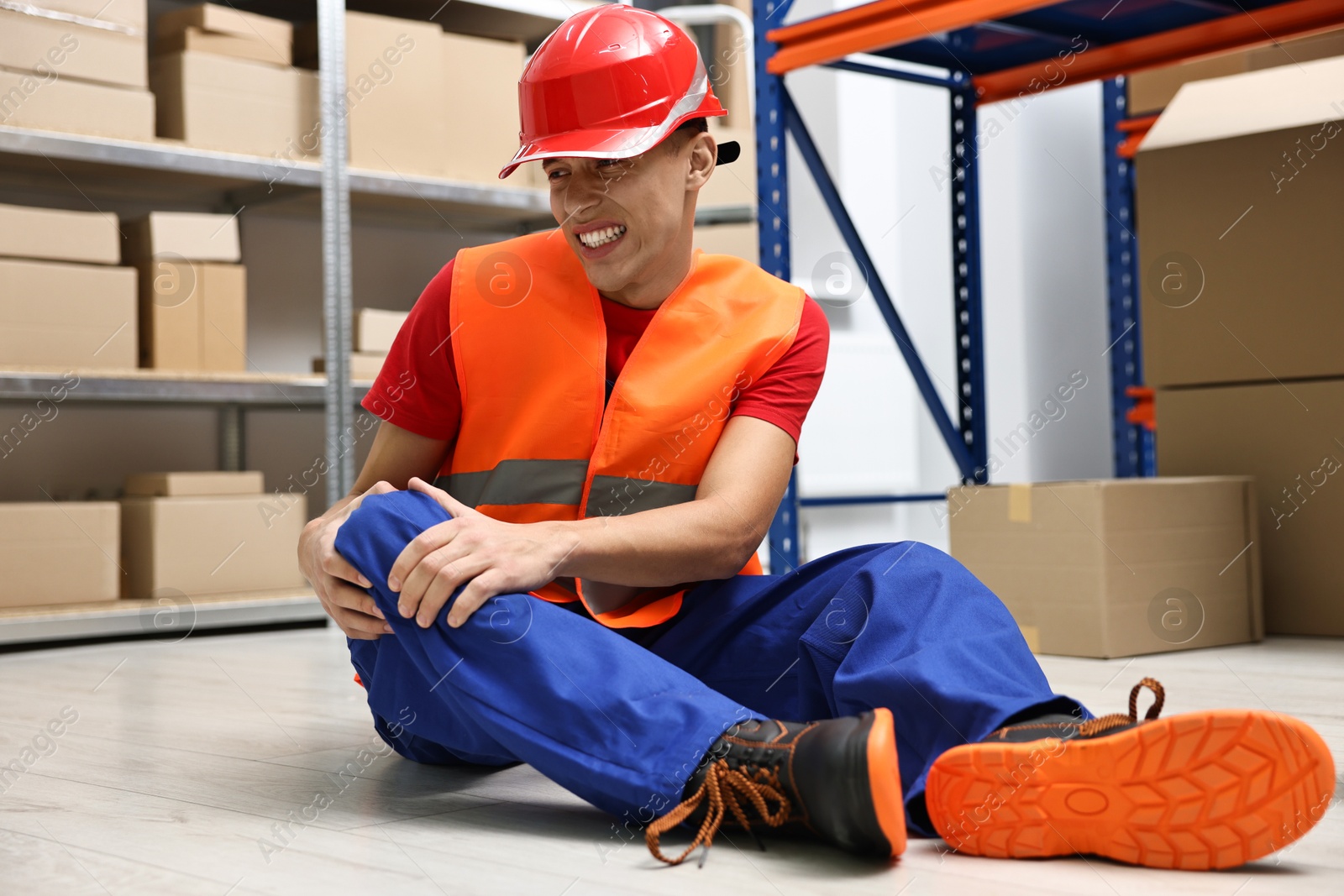 Photo of Accident at work. Injured man on floor in warehouse