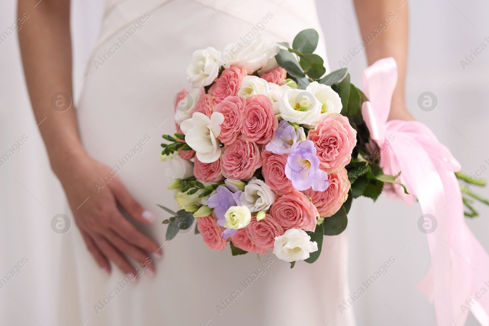 Photo of Bride with beautiful wedding bouquet on light background, closeup